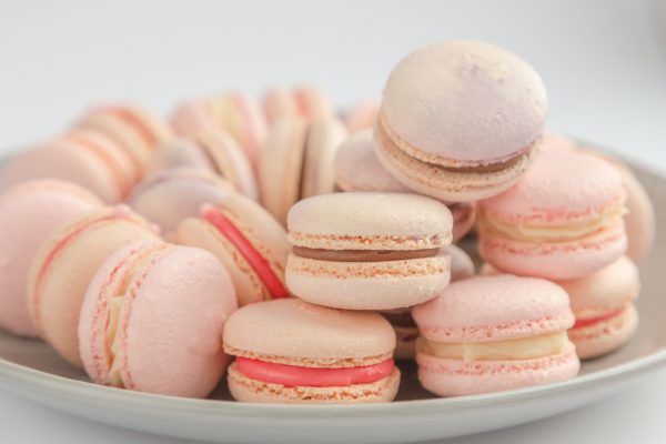 pink and white macaroons on white ceramic bowl